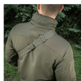 Mies kantaa M-Tac Sling Pistoltaske Elite Hexiä säädettävällä olkahihnalla ulkoilmassa.