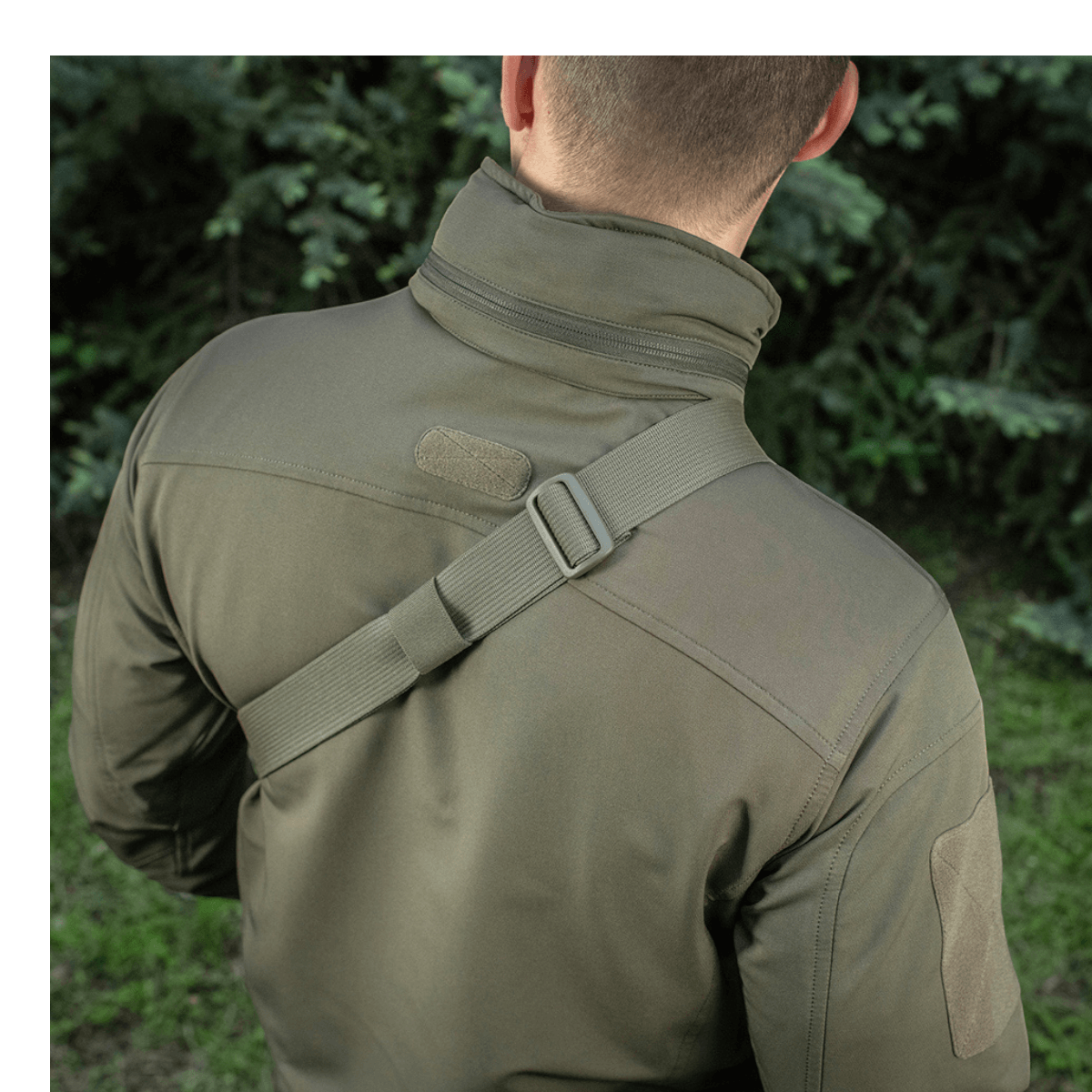 Mies kantaa M-Tac Sling Pistoltaske Elite Hexiä säädettävällä olkahihnalla ulkoilmassa.