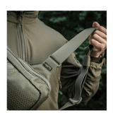 Mies kantaa M-Tac Sling Pistoltaske Elite Hexiä säädettävällä olkahihnalla Cordura-materiaalista.