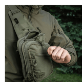 M-Tac Sling Pistoltaske Elite Hex säädettävällä olkahihnalla henkilöllä ulkoilmassa.