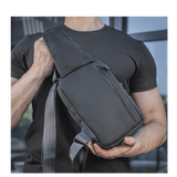 Henkilö kantaa M-Tac Sling Pistoltaske Elite Hexiä, mukava ja kestävä laukku säädettävällä olkahihnalla ja kestävästä materiaalista.