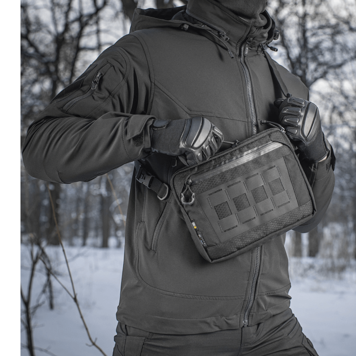 Henkilö, jolla on M-Tac Admin-laukku Elite, talvisessa metsässä