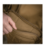 Henkilö avaa taskun M-Tac Admin-laukusta Elite, kestävä Cordura-materiaali ja YKK-vetoketjut