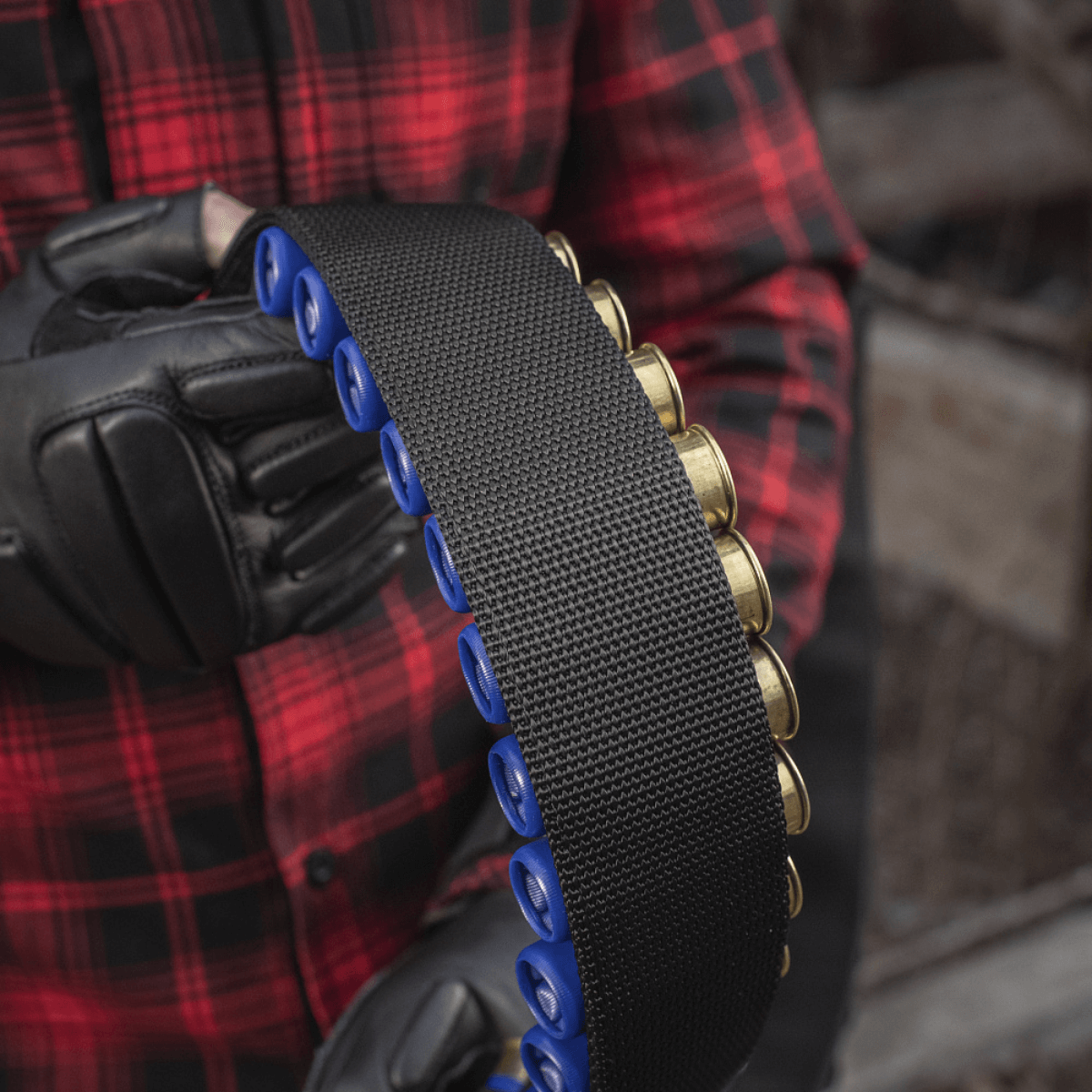 Henkilö pitelee M-Tac Bandolier Elitea, patruunavyötä jossa 55 patruunapaikkaa, sopii metsästykseen ja ampumaurheiluun.