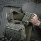 Henkilö esittelee M-Tac olkatyynyn Plate Carrier Cuirass QRS, korkealaatuinen Cordura ja 3D-mesh mukavuuteen ja tuuletukseen