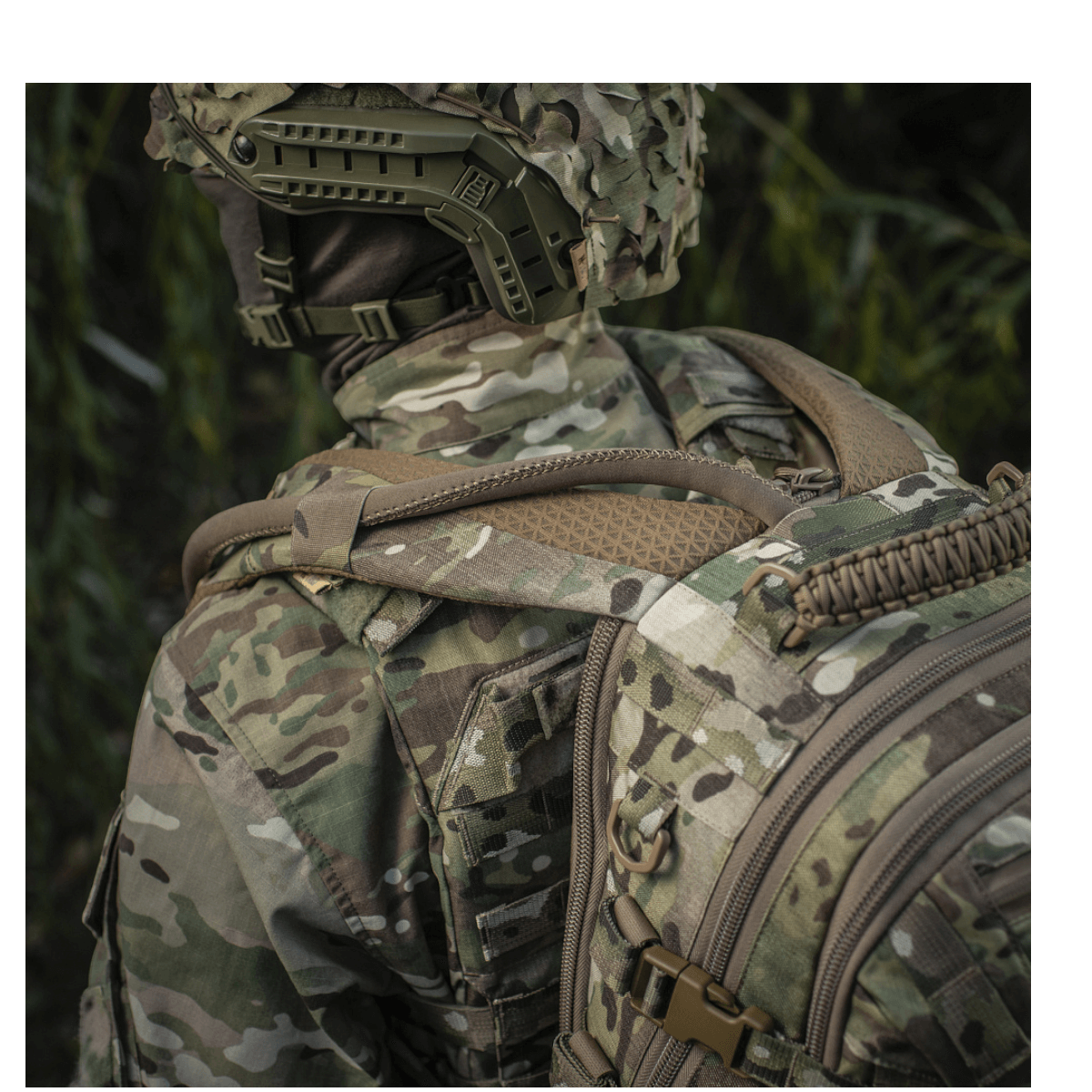 Henkilö camokuvioisessa asussa kantaa M-Tac Mission Pack Elitea MOLLE LASER CUT -järjestelmällä metsässä ergonomista toimivuutta varten.