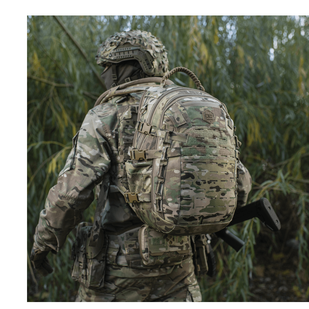 M-Tac Mission Pack Elite reppu camo-kuvioituna, MOLLE LASER CUT-system metsäalueella.
