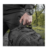 Mies pitää M-Tac Mission Pack Elite -reppua, jossa MOLLE LASER CUT-system ja Cordura 1000D -materiaali.