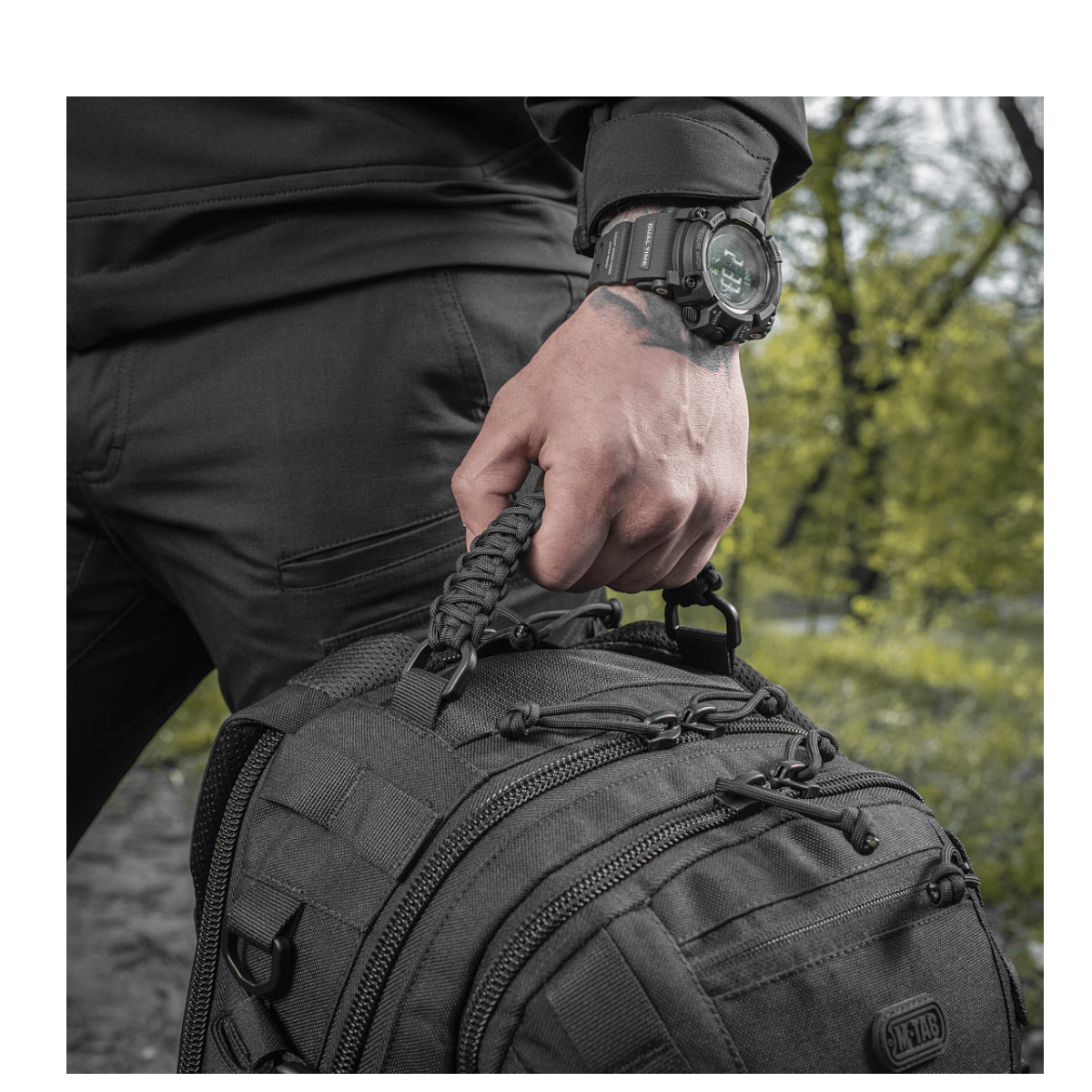 Mies pitää M-Tac Mission Pack Elite -reppua, jossa MOLLE LASER CUT-system ja Cordura 1000D -materiaali.