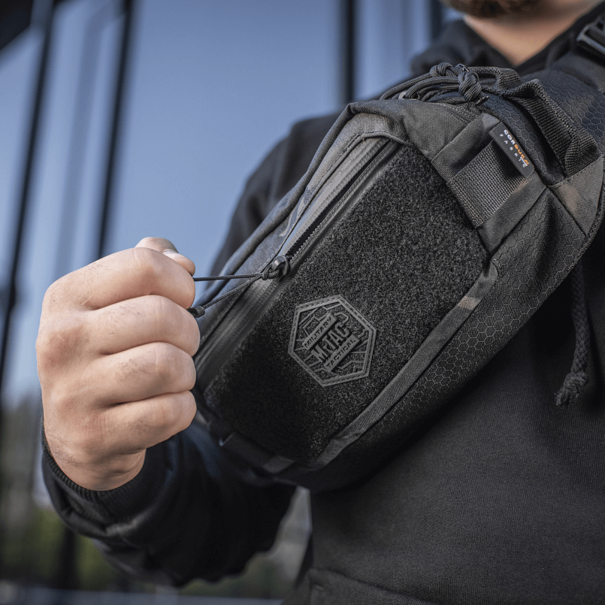 M-Tac Elite Hex -vyölaukku käytössä, näyttää kestävän muotoilun Cordura-kankaasta, YKK-vetoketju ja Woojin-soljet, sopii arkeen.