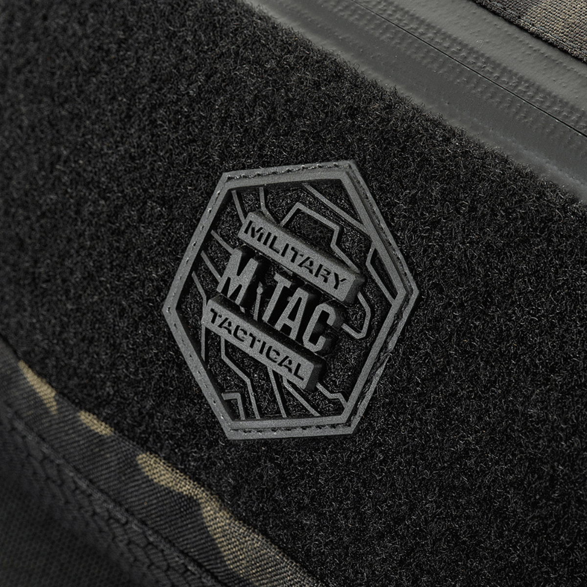 M‑Tac Elite Hex -vyölaukku Hex-logolla ja taktillisella muotoilulla, lähikuva mustasta Cordura-kankaasta ja vedenpitävästä vetoketjusta.