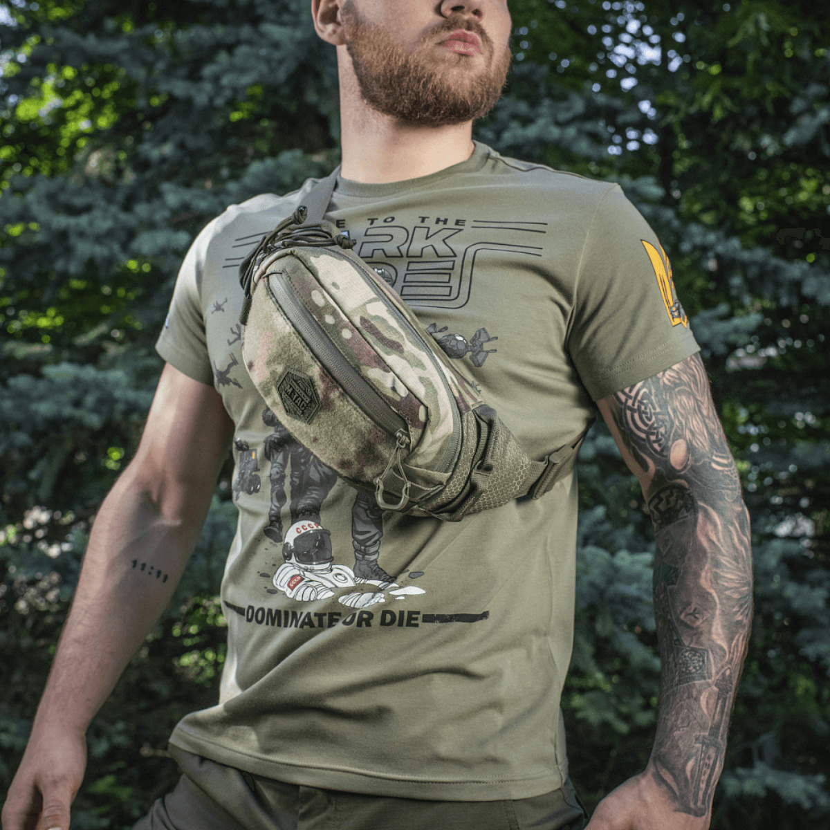 M‑Tac Elite Hex -vyölaukku miehellä metsässä, tyylikäs ja toimiva Cordura-materiaalin ja taktisten taskujen ansiosta.