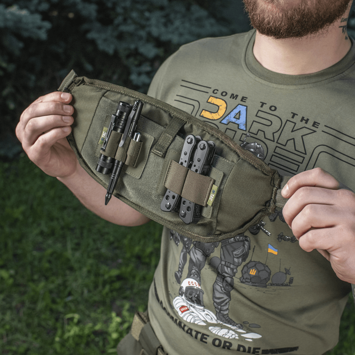 M-Tac Elite Hex -vyölaukku käytössä, kompakti muotoilu taktisen varustuksen kanssa, materiaalit Cordura 500D ja 1000D, YKK-vetoketjut ja Woojin-soljet.