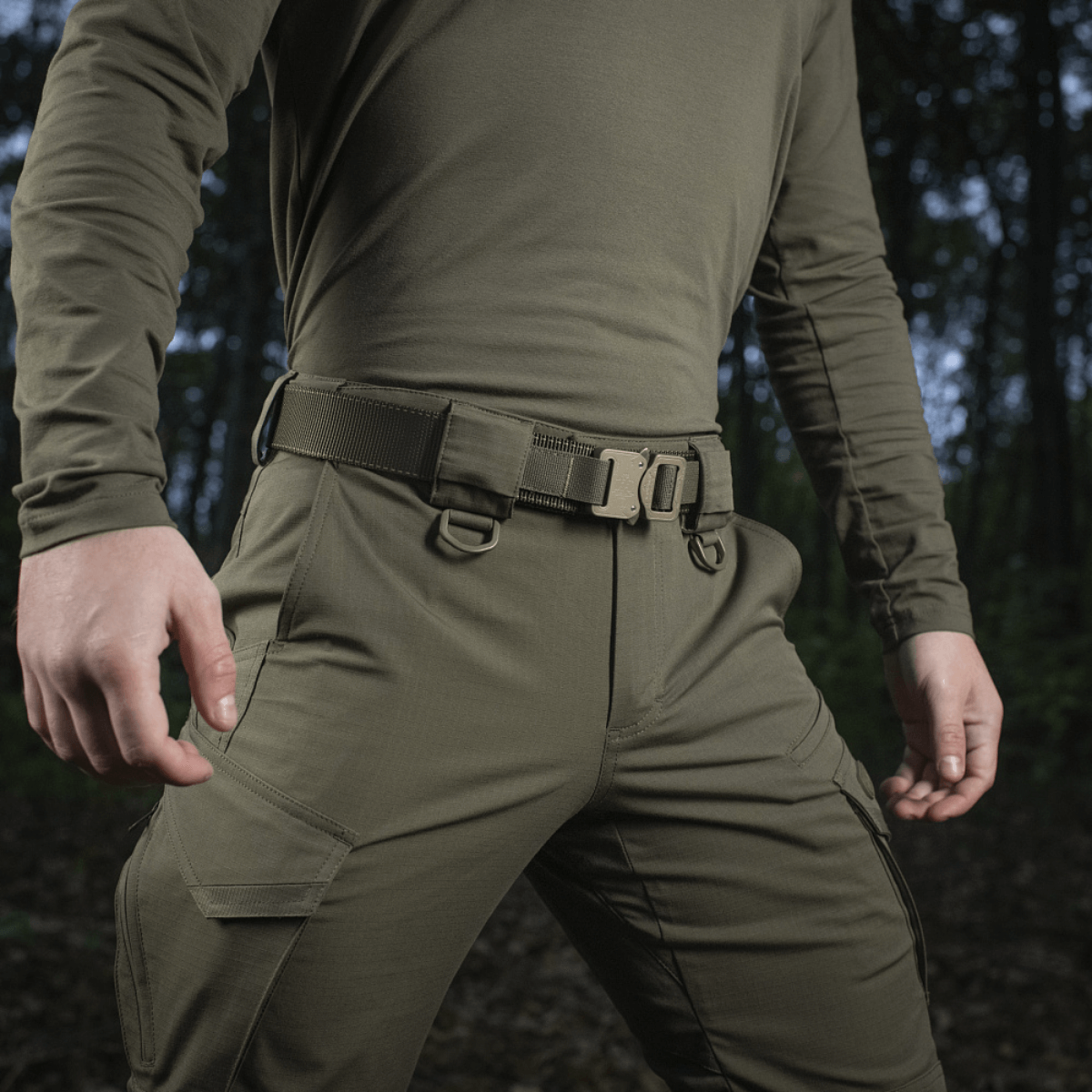 M-Tac taktinen vyö Cobra-lukolla esitetty ulkotaktisessa ympäristössä, vahva ja kulutusta kestävä nylon-webbing sotilaskäyttöön.