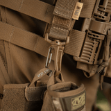 M-Tac karabiinihaka-lisävaruste kiinnitetty taktiseen MOLLE-reppuun, helppo kiinnitys Velcro-remmillä ja kevyt muotoilu.