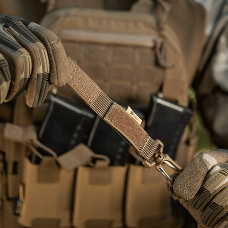 M-Tac karabiinihaka-lisävaruste kiinnitetty taktiseen MOLLE-liiviin Velcro-remmillä varusteiden kiinnitykseen.