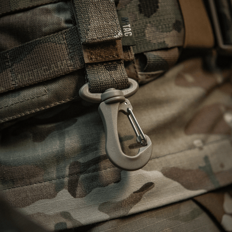 M-Tac karabiinihaka-lisävaruste kiinnitetty MOLLE-reppuun camouflagemallilla, kevyt ja käytännöllinen taktiseen käyttöön.