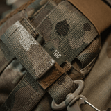 M-Tac karabiinihaka-lisävaruste kiinnitettynä MOLLE-järjestelmään, kevyt ja kompakti karabiinihaka säädettävällä Velcro-remmillä ja varma lukitus.