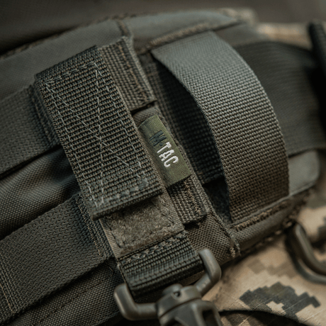 M-Tac karabiinihaka-lisävaruste kiinnitetty MOLLE-järjestelmään Velcro-remmillä, täydellinen taktiseen varustukseen, kevyt ja kompakti muotoilu.