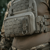 M-Tac-kiinnike D-renkaalla asennettuna taktiseen liiviin MOLLE-järjestelmän avulla varusteiden turvalliseen ripustukseen Velcro-sulkimella.
