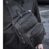 Mies kantaa M-Tac Cross Taske Slim Elite Hex -laukkua mustana olallaan.