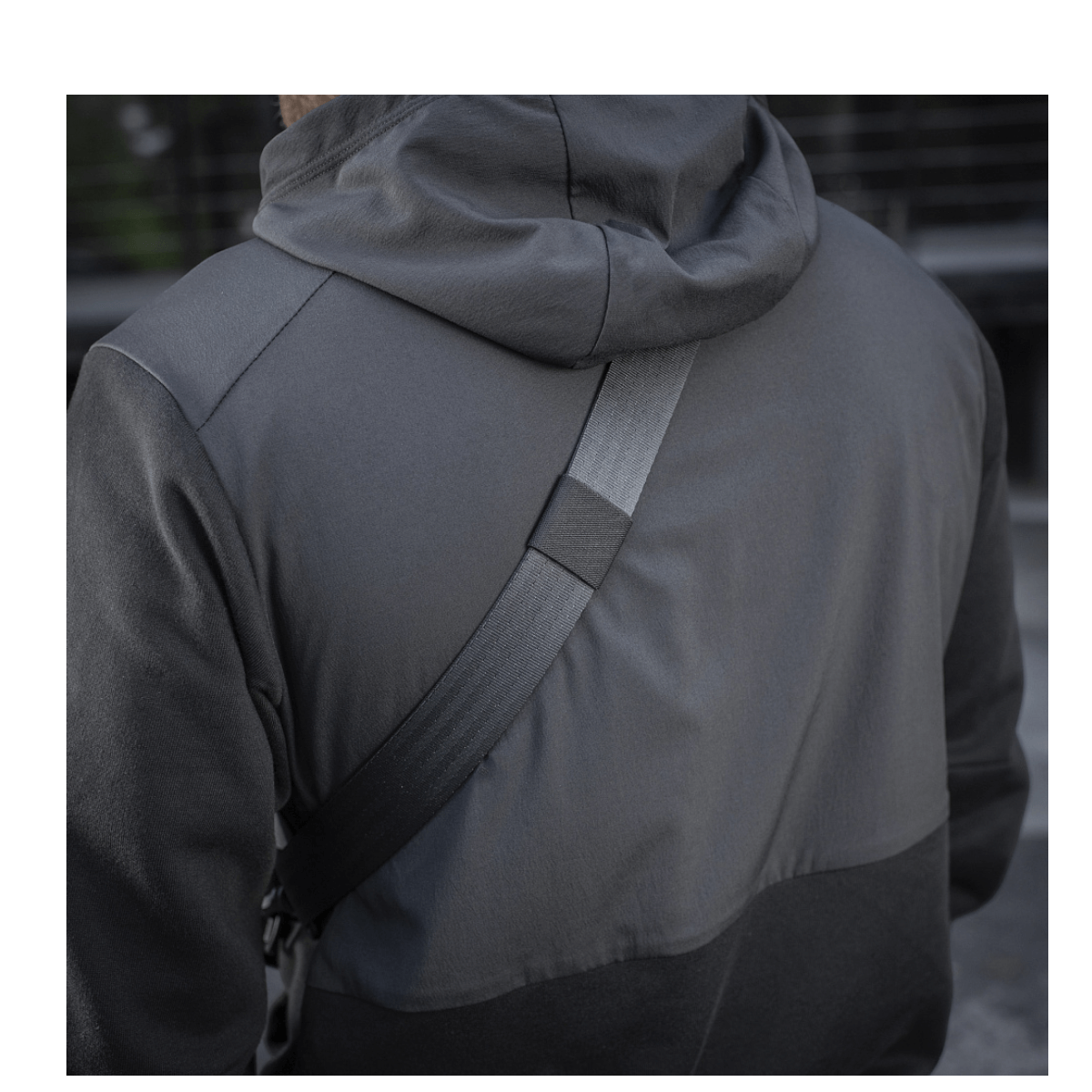 Henkilö, jolla on M-Tac Cross Taske Slim Elite Hex ja musta takki.