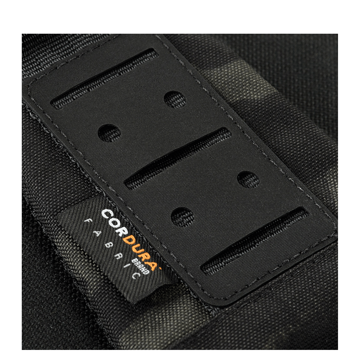 Yksityiskohtia M-Tac Cross Taske Slim Elite Hex -laukusta tukevassa Cordura-materiaalissa, tyylikäs muotoilu.