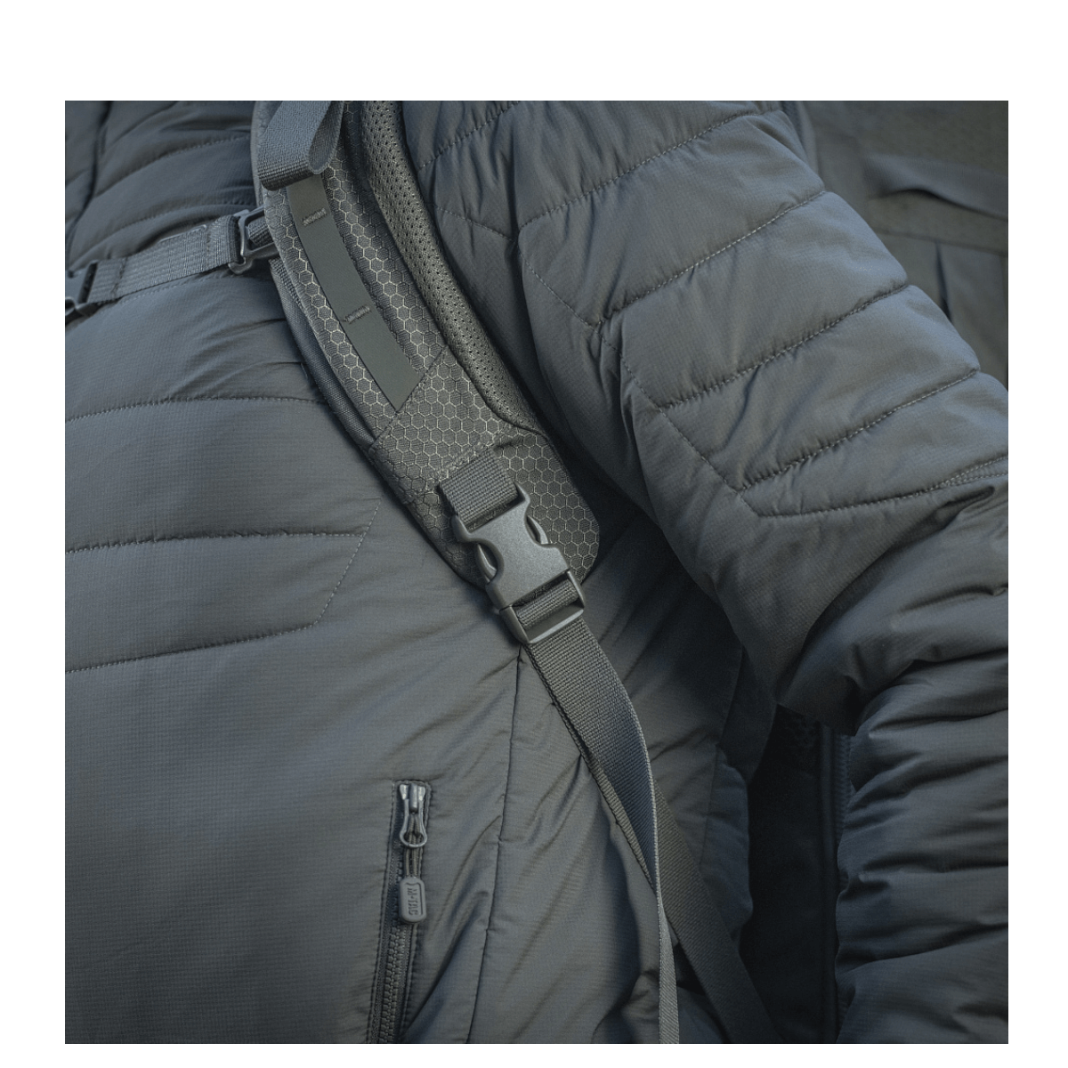 Lähikuva M-Tac reppu Large Elite Hex Gen. IV henkilöllä takki päällä, näyttää ergonomisen muotoilun ja vahvan rakenteen.