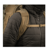 Mies käyttää M-Tac reppu Large Elite Hex Gen. IV pehmustetulla olkahihnalla, suunniteltu mukavuuteen ja toiminnallisuuteen ulkokäytössä.