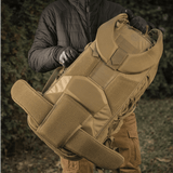 Henkilö pitää M-Tac reppu Large Elite Hex Gen. IV, tehty tukevista materiaaleista, sopii aseiden kantamiseen luonnossa.