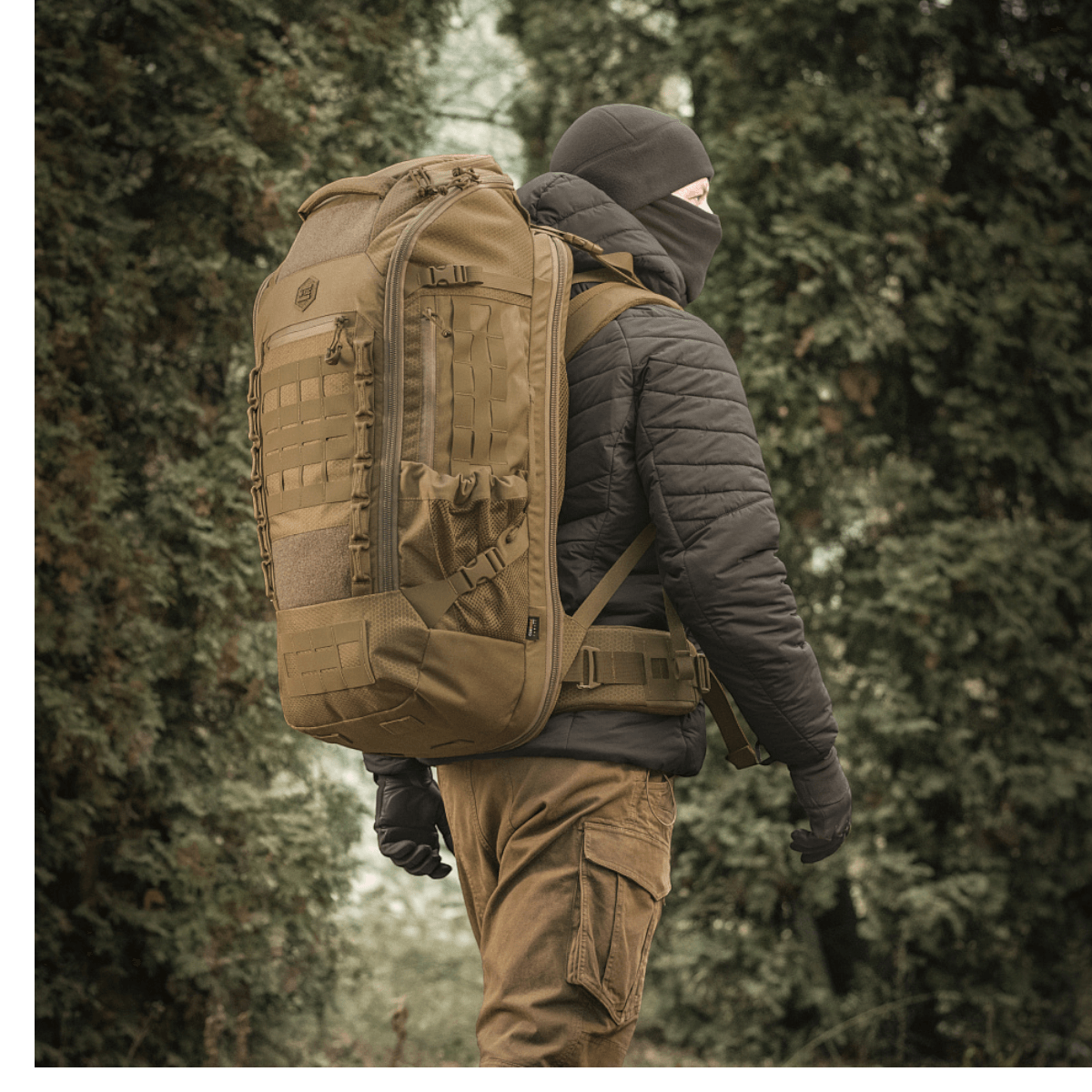 Henkilö käyttää M-Tac reppu Large Elite Hex Gen. IV luonnossa, suunniteltu kestävyyteen ja toimivuuteen.
