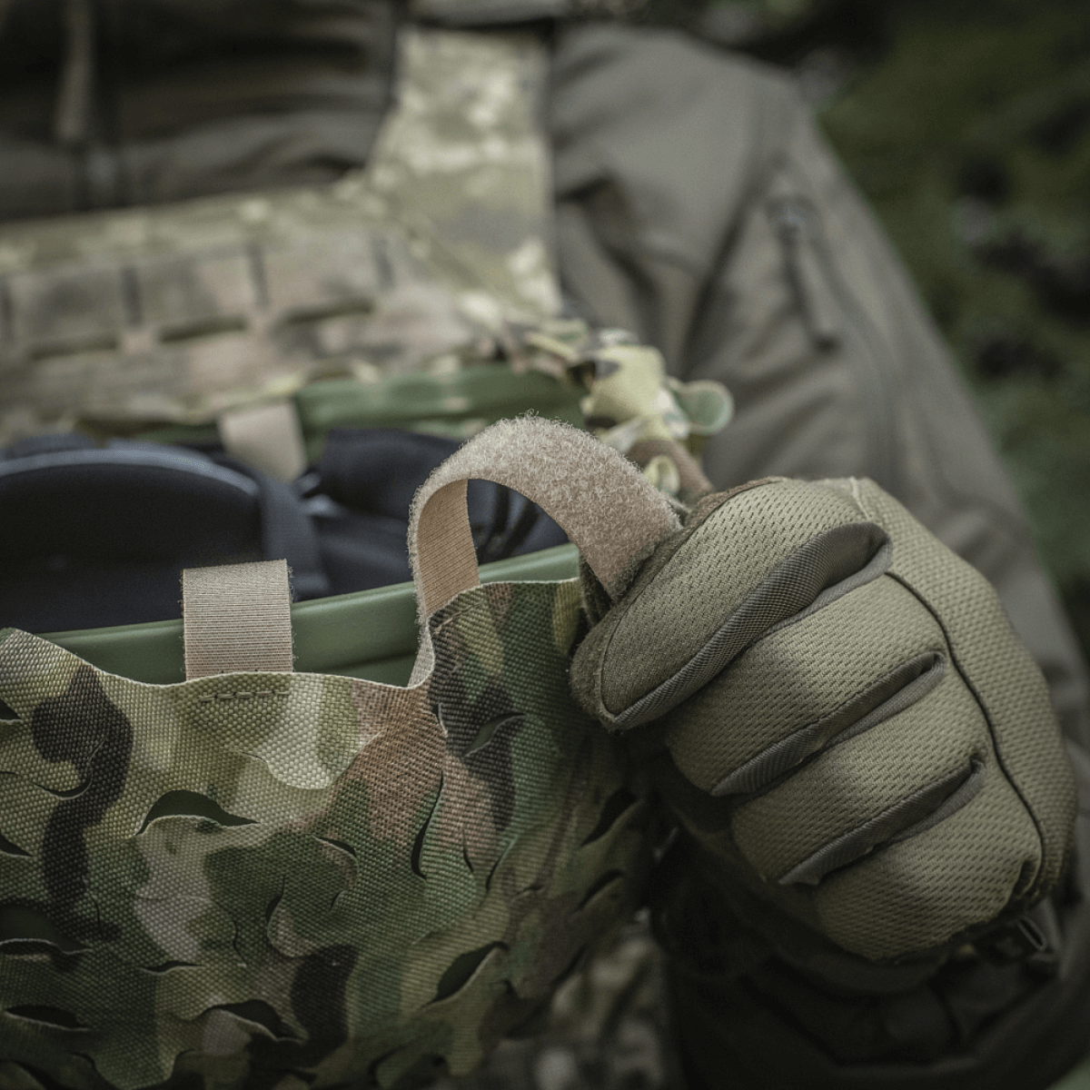 M-Tac Vilha Hjelmcover Elite Multicam-camossa kypärään kiinnitettynä, valmistettu Cordura 500D:stä, Velcro-paneelit og chokledning.