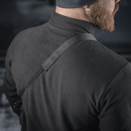 M-Tac Pocket Bag Elite HEX kannetaan olkapäällä miehellä mustassa takissa, näyttää hihnan kestävyyden ja kantomukavuuden.