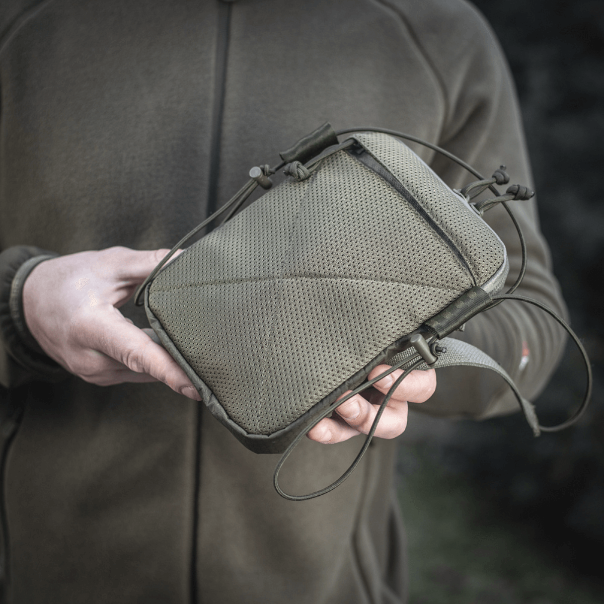 Henkilö pitää M‑Tac Pocket Bag Elite HEXiä, kompakti kestävä laukku päivittäisten pikkutavaroiden ja varusteiden säilytykseen.