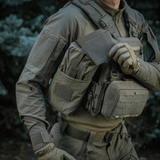 M‑Tac Medic Pouch Vertical Large Elite käytössä kentällä, kiinnitetty taktiseen liiviin helppoa pääsyä ensiapuvälineisiin varten.