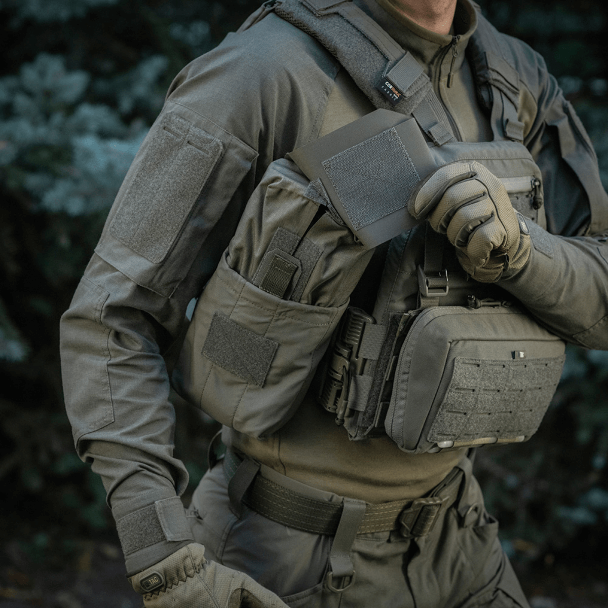 M‑Tac Medic Pouch Vertical Large Elite käytössä kentällä, kiinnitetty taktiseen liiviin helppoa pääsyä ensiapuvälineisiin varten.
