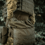 Henkilö kantaa M-Tac Pouch Sukharka Gen.3 XL:ää kiinnitettynä MOLLE-järjestelmään; näyttää Cordura 500D -materiaalin kestävyyden kentällä.