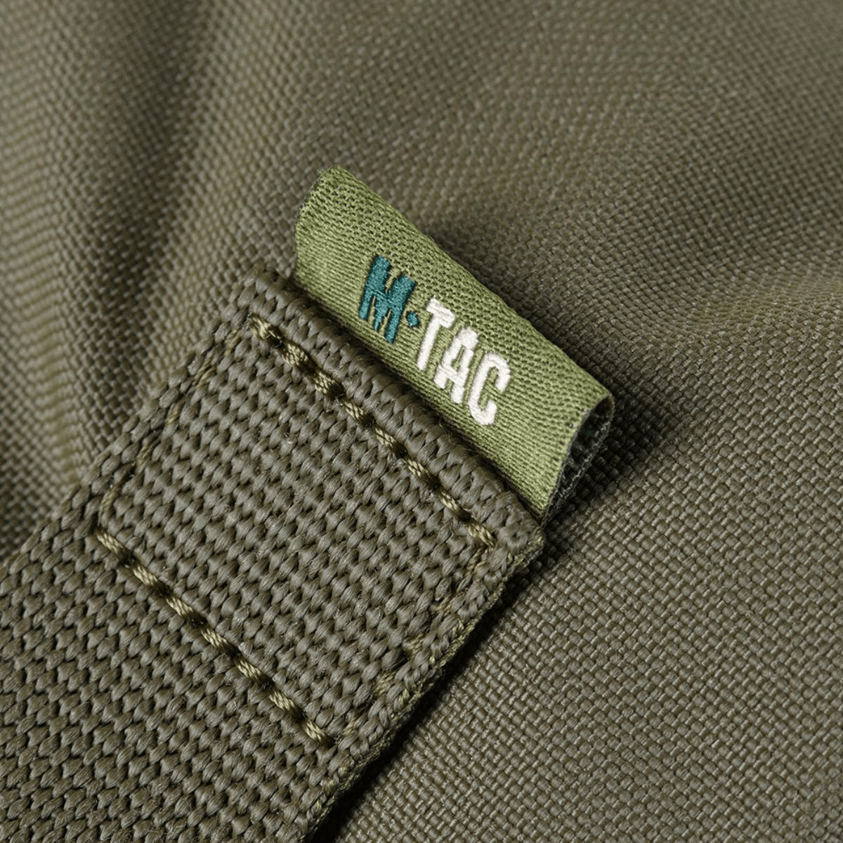 Yksityiskohta M-Tac Pouch Sukharka Gen.3 XL:stä, Cordura 500D ja M-Tac-logon ommel.