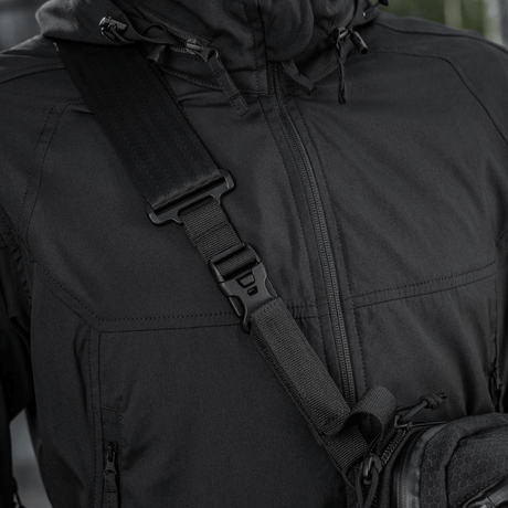 Lähikuva mustasta M-Tac Tablet Bag Laser Cut Hex -olkalaukusta henkilöllä, valmistettu kestävästä Cordura-materiaalista, säädettävä hihna.