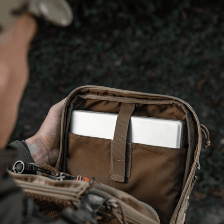 Henkilö avaa M-Tac Tablet Bag Laser Cut Hex -laukkuun, sisältää tabletin ja asiakirjoja.