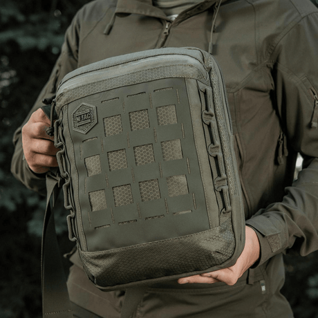 M-Tac Tablet Bag Laser Cut Hex Laser Cut MOLLE -paneelilla, Cordura-materiaaleista, pidetään henkilön toimesta ulkoilmassa.
