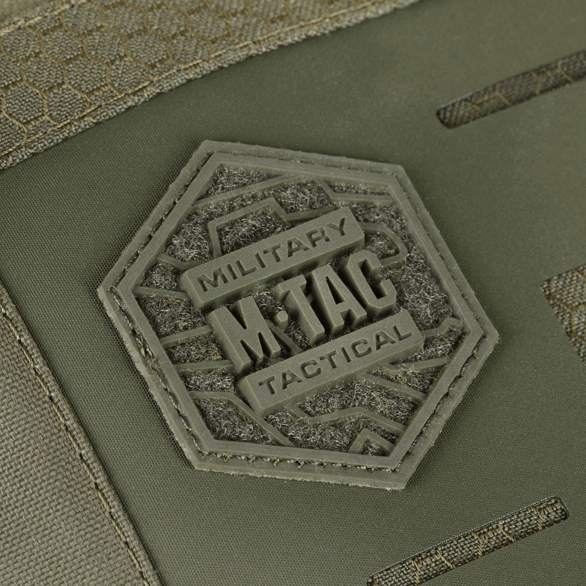 Lähikuva M-Tac Tablet Bag Laser Cut Hex -logosta kuusikulmiossa etupaneelissa, Cordura Hex -materiaalia oliivinvihreänä.
