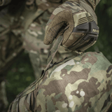 Henkilö maastohanskoissa nostaa M-Tac Sukharka Gen.3 Pouchin, Cordura 500D.
