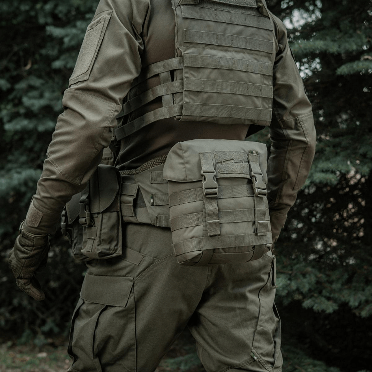 Sotilas metsässä M-Tac Sukharka Gen.3 Pouch kiinnitettynä sotilasasuun.