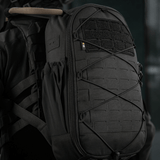 M-Tac STURM Elite -reppu MOLLE Laser Cut -muotoilulla ja Cordura-materiaalilla henkilön selässä, sivusta nähtynä.
