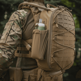 M-Tac STURM Elite -reppu käytössä, näyttää MOLLE Laser Cut -paneelin ja sivutaskun, sopii taktiseen käyttöön, valmistettu Cordura-materiaalista.