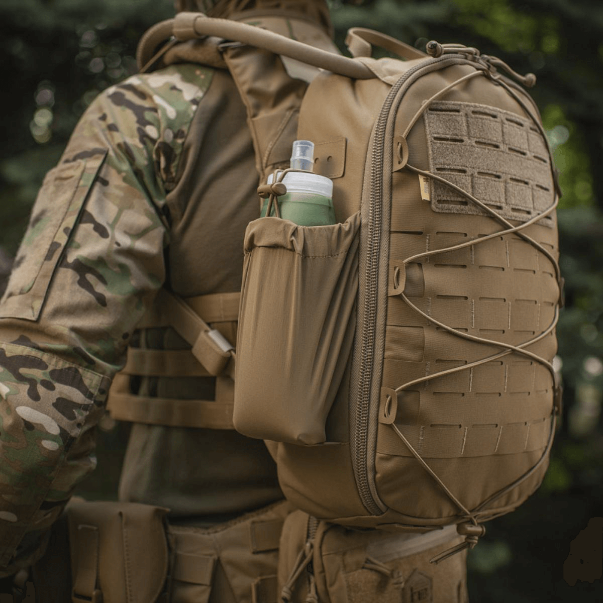 M-Tac STURM Elite -reppu käytössä, näyttää MOLLE Laser Cut -paneelin ja sivutaskun, sopii taktiseen käyttöön, valmistettu Cordura-materiaalista.
