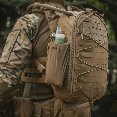 M-Tac STURM Elite -reppu käytössä, näyttää MOLLE Laser Cut -paneelin ja sivutaskun, sopii taktiseen käyttöön, valmistettu Cordura-materiaalista.
