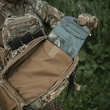 Sotilas M-Tac STURM Elite -repun kanssa ulkona, MOLLE-järjestelmä ja Cordura-materiaalit, näyttää tilavuuden ja taktisen muotoilun.