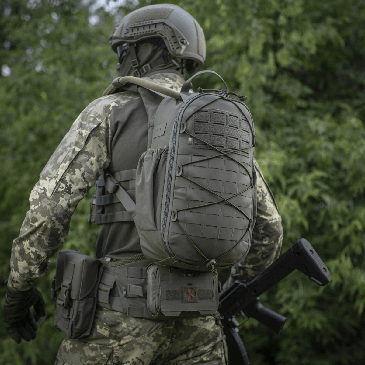 M-Tac STURM Elite -reppu MOLLE Laser Cut -paneelilla käytössä maastopuvussa olevan sotilaan päällä, sopii taktiseen kenttäkäyttöön.